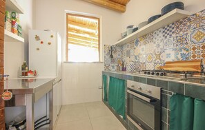 A compact kitchen with a refrigerator, oven, and stove, tiled backsplash, and a window with blinds. - Stunning home in Perdifumo with house a panoramic view (Perdifumo)