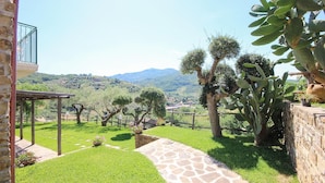 A courtyard with a stone pathway, cacti, and a view of distant hills. - Stunning home in Perdifumo with house a panoramic view (Perdifumo)