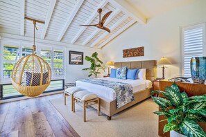 A bedroom with a bed, bedside tables, a hanging chair, and a large window. - Kapalua Bay | Ocean View 3 BR, Sleeps 10 | Car Incl. w/ 6+ Nights | KBV ML-2092 by KBM (Lahaina)