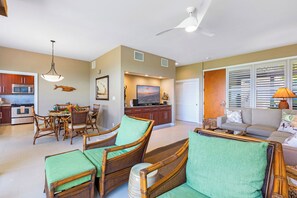 A spacious living area with a dining table, wicker furniture, a television, and a ceiling fan. - Kapalua Bay | Ocean View 3 BR, Sleeps 10 | Car Incl. w/ 6+ Nights | KBV ML-2092 by KBM (Lahaina)
