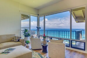Ein geräumiger Balkon mit Meerblick, ausgestattet mit einer Couch, Stühlen und einem kleinen Tisch.