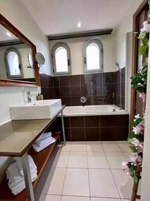A modern bathroom with a large sink, a bathtub, and a shower. There are two windows with arched tops and a mirror above the sink. - Apartment-Luxury-Ensuite with Bath-Terrace-Bord de Mer (Juan-les-Pins)
