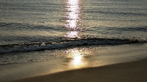 En strand med solens refleksioner i vandet.