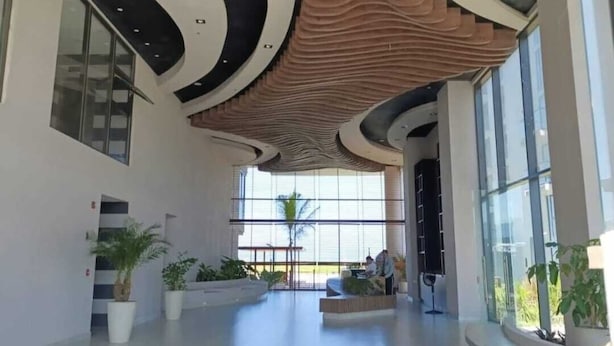 En rummelig lobby med et moderne loftdesign, store vinduer og potteplanter.