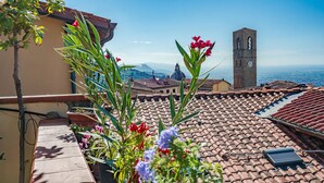 A rooftop terrace with terracotta tiles, a clock tower, and a mountainous backdrop. - Lovely apartment in Massa e Cozzile (Massa e Cozzile)
