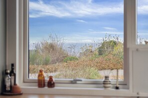 A window with a view of a garden and a clear sky. - Stylish, energy-efficient holidayhome near by sea (Allingåbro)