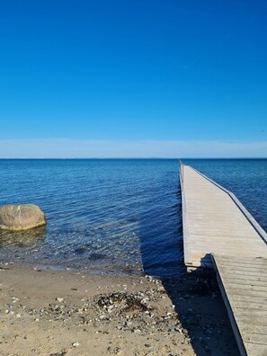 A wooden pier extending into calm waters with a clear sky above. - Cozy holiday home on Funen’s north coast (Bogense)