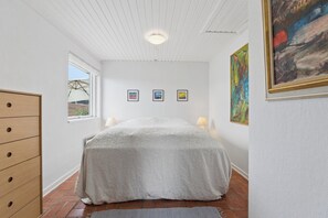A bedroom with a bed, a dresser, a window, and wall art. - Cozy holiday home on Funen’s north coast (Bogense)