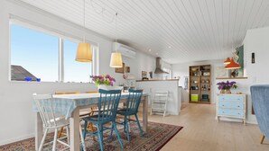 A modern kitchen with a dining area, large windows, and a view of the sky. - Cozy holiday home on Funen’s north coast (Bogense)