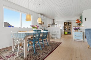 A modern kitchen with a dining area, large windows, and a view of the sky. - Cozy holiday home on Funens north coast (Bogense)