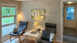 A cozy room with two leather chairs, a small table, and wall art. - Lovely home in Væggerløse with sauna (Væggerløse)