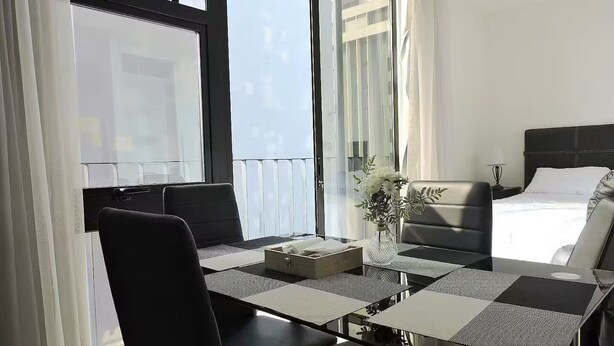 Ein modernes Hotelzimmer mit einem Bett, einem Esstisch und einer Sitzecke.