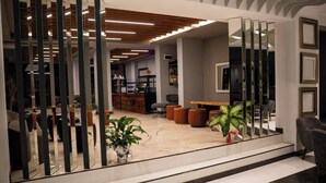 A modern interior with a reception desk, seating area, and a staircase leading to upper floors. - Altuncu Premium Termal Hotel (Armutlu)