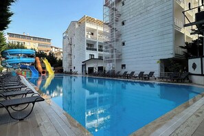 Una piscina al aire libre de temporada, sombrillas