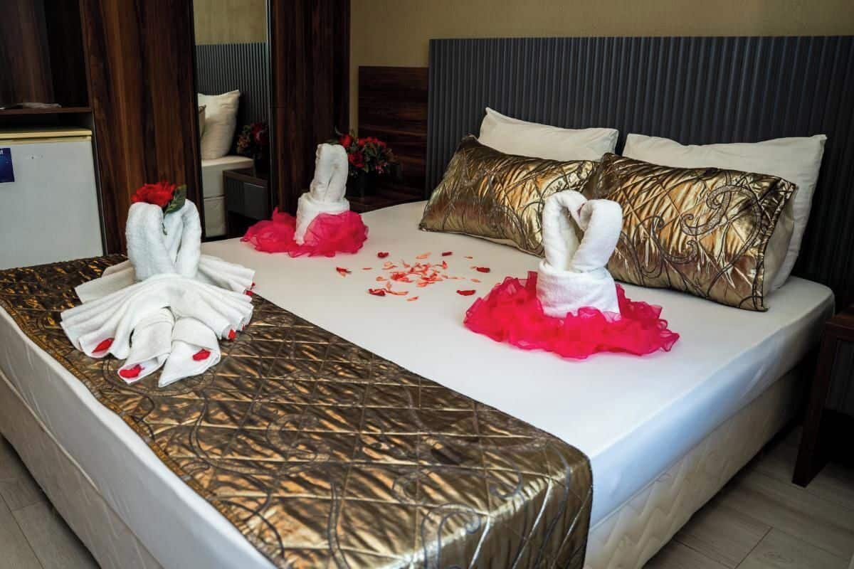 Una habitación de hotel con cama, almohadas y un perchero para toallas.