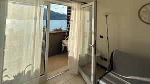 Una habitación con vista a un lago, un sofá, una lámpara y un aplique.