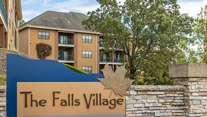 A sign for The Falls Village with a blue background and a leaf design. - BLOCK Falls Village 1br (Angels Camp)