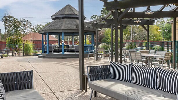 An outdoor patio area with a gazebo, seating, and a playground in the background. - BLOCK Falls Village 1br (Angels Camp)