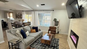 A modern living room with a sofa, armchairs, a coffee table, and a fireplace. - One story 4 bedroom updated ranch in the middle of it all. (Simpsonville)