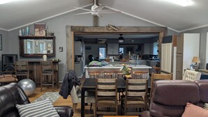 A spacious living room with a dining area, a kitchen in the background, and a ceiling fan. - large ski ranch hot tub close to killington pets ok (Mendon)