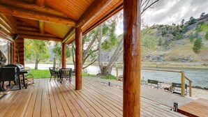 A wooden deck with a grill and chairs, overlooking a river and hills. - 'Riverfront Ranch' Craig, Montana (Cascade)