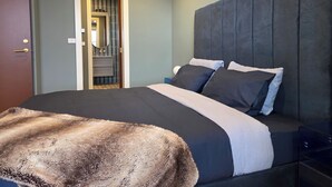 A modern bedroom with a large bed, a dark headboard, and a fur throw. - Luxury accommodation Jindabyne. Weekly and monthly discounts (Jindabyne)