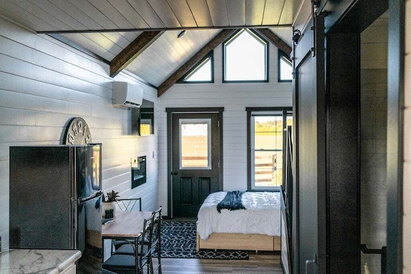 The bedroom has a queen sized bed, electric fireplace, and TV for cozy, restful evenings