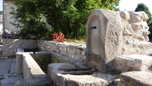A stone structure with a well, steps leading up to it, and a small arched opening. - La Grange - CAMURAC - Gîte (CAMURAC)