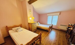 A bedroom with a wooden bed, a smaller bed, a dresser, a lamp, and a window. - Coté colline - ANTUGNAC (ANTUGNAC)