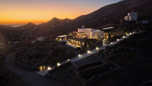 A modern building with a pathway leading to it, surrounded by rocky terrain and mountains. - Heavenly views from Villa Nites with stunning infinity pool (Megas Gialos)