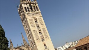 A historic tower with intricate architectural details, a central courtyard, and a fountain. - 2BR Cathedral & Giralda Views, Rooftop Terrace! (Sevilla)