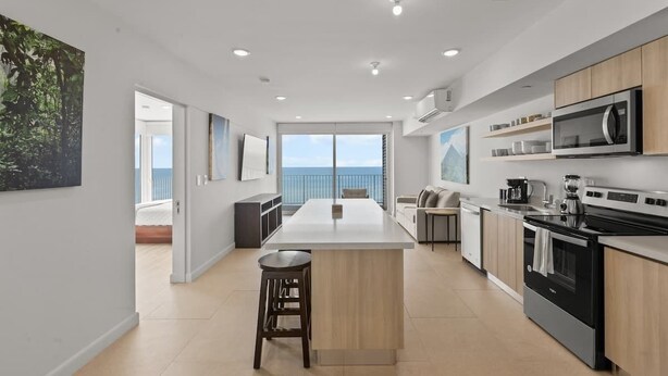 Una cocina moderna con una isla central, electrodomésticos integrados y vistas al exterior.