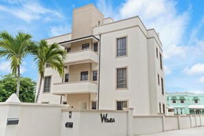 Un edificio moderno a più piani con facciata piatta, balconi e un cartello con su scritto "WIMBA".