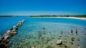 A clear blue sea with a rocky breakwater and a sandy beach. - Coastal Haven in Sebastian W/ Heated Saltwater Pool, BBQ Grills, Fire Pit & Near Beaches!🌴 (Sebastian)