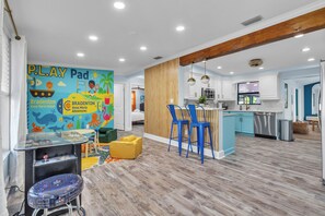 A modern kitchen with white cabinets, a stainless steel refrigerator, and a blue island. - Near IMG & AMI! Sleeps 10 • Heated Pool • Pickleball • Tiki Bar • Luxury Home (Bradenton)