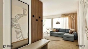 Uma sala de estar moderna com um sofá cinzento, uma parede de destaque em madeira e uma grande obra de arte abstrata.
