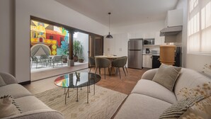 Ein modernes Wohnzimmer mit einem Glastisch, einer Couch und einem Essbereich mit Stühlen und einem Tisch.