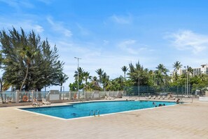A swimming pool with lounge chairs and palm trees. - Beachfront King Suite • Pool • Parking• Walk2Eat (Carolina)