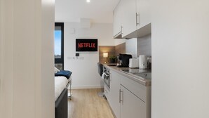 A modern kitchenette with a built-in oven, a coffee maker, and a sink. - The Point 902 - Grampian Lettings (Aberdeen)