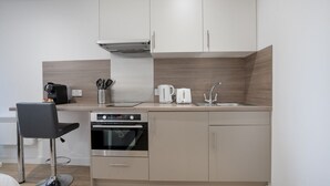 A compact kitchen with a built-in oven, a coffee maker, and a toaster. - The Point 922 - Grampian Lettings (Aberdeen)