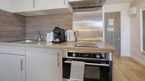 A modern kitchen with a stainless steel range hood, a coffee maker, and a toaster. - The Point 925 - Grampian Lettings (Aberdeen)