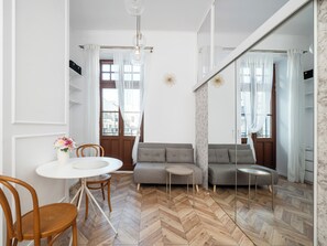 En moderne stue med sofa, spisebord med stole og et gulv med et fiskebensmønster.