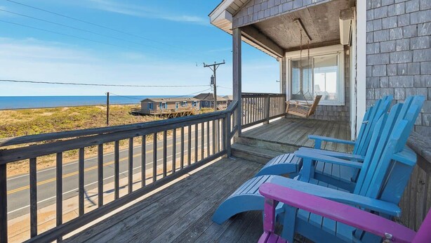 A wooden deck with blue and pink Adirondack chairs overlooking a beach. - Babe's Place | 105 ft to the beach | Dog Friendly (Kill Devil Hills)