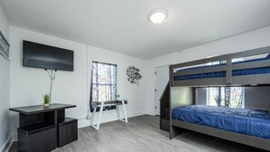 A modern bedroom with bunk beds, a desk, and a TV. - Chill Studio Pensacola Getaway (Pensacola)