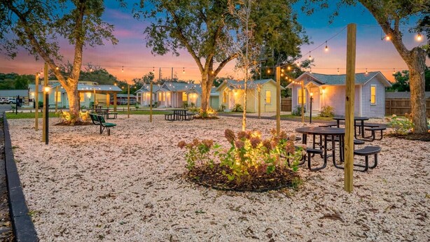 A campground with multiple cabins, picnic tables, and string lights. - Chill Studio Pensacola Getaway (Pensacola)