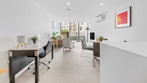Espaço de escritório moderno com balcão de recepção, área de estar e vista para a paisagem urbana.