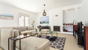 A modern living room with a sofa, coffee table, and TV stand. - Blue Heaven Luxury V5 (Porches)