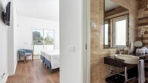 A modern bedroom with a bed, a chair, and a large window. - Luxury Vau Beach Villa with Private Heated* Pool (Portimão)
