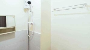 Une salle de bain avec une douche, un porte-serviettes et un miroir.