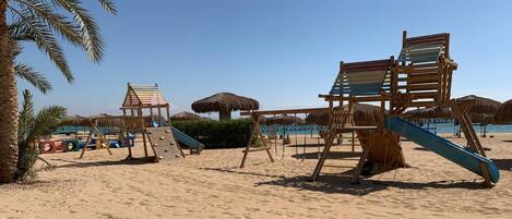 Rannalla, aurinkotuoleja, rantapyyhkeitä